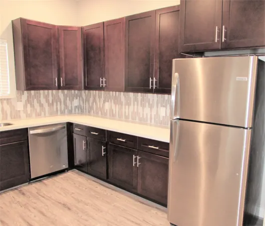 a kitchen with stainless steel appliances granite countertop wooden cabinets a stove top oven a sink and dishwasher