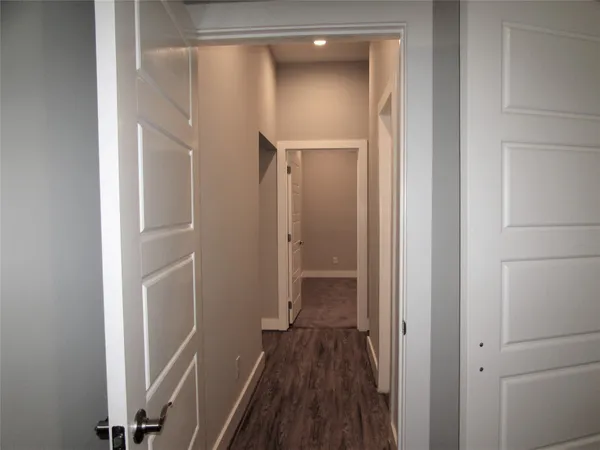 a view of a hallway with wooden floor