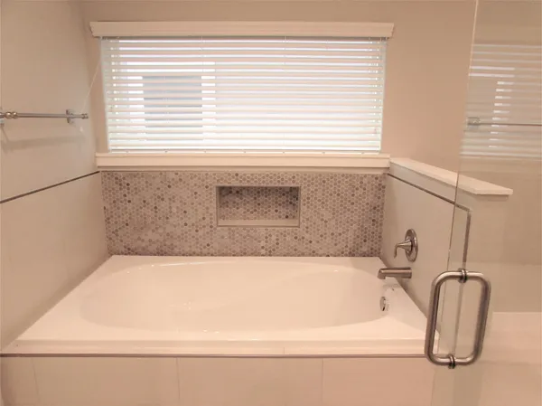 a bathroom with a granite countertop sink and a window