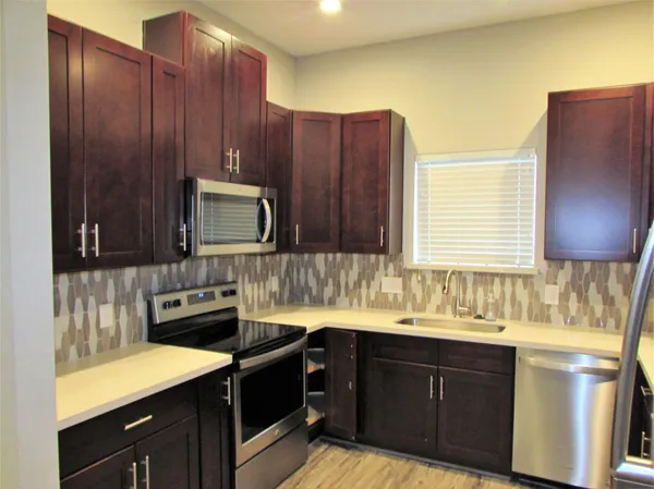 a kitchen with a sink stove and cabinets