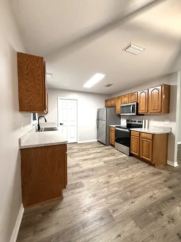 a kitchen with stainless steel appliances a sink stove and refrigerator