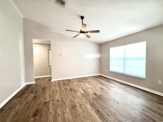 wooden floor in an empty room with a window
