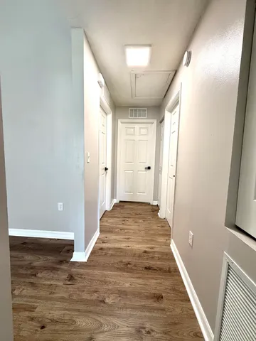 a view of a hallway with wooden floor