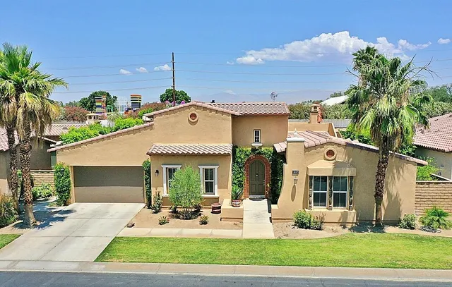 a front view of a house with garden and patio
