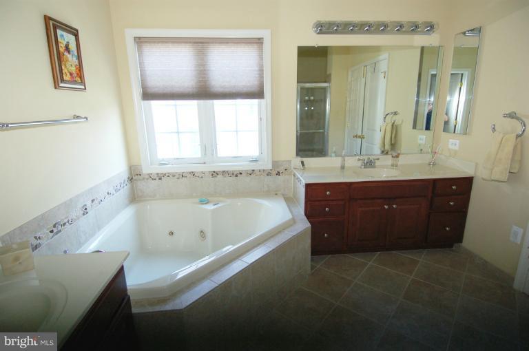 1309 Rome Court Odenton, MD 21113 - Photo 3 of 30 a spacious bathroom with a tub sink and mirror