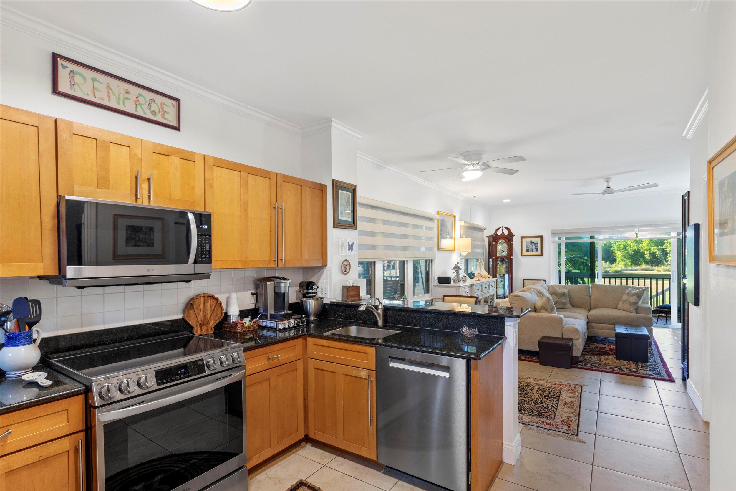 44 Spoonbill Way, Unit 1 Key West, FL 33040 - Photo 19 of 83 a kitchen with stainless steel appliances granite countertop a stove top oven a sink dishwasher a dining table and chairs with wooden floor