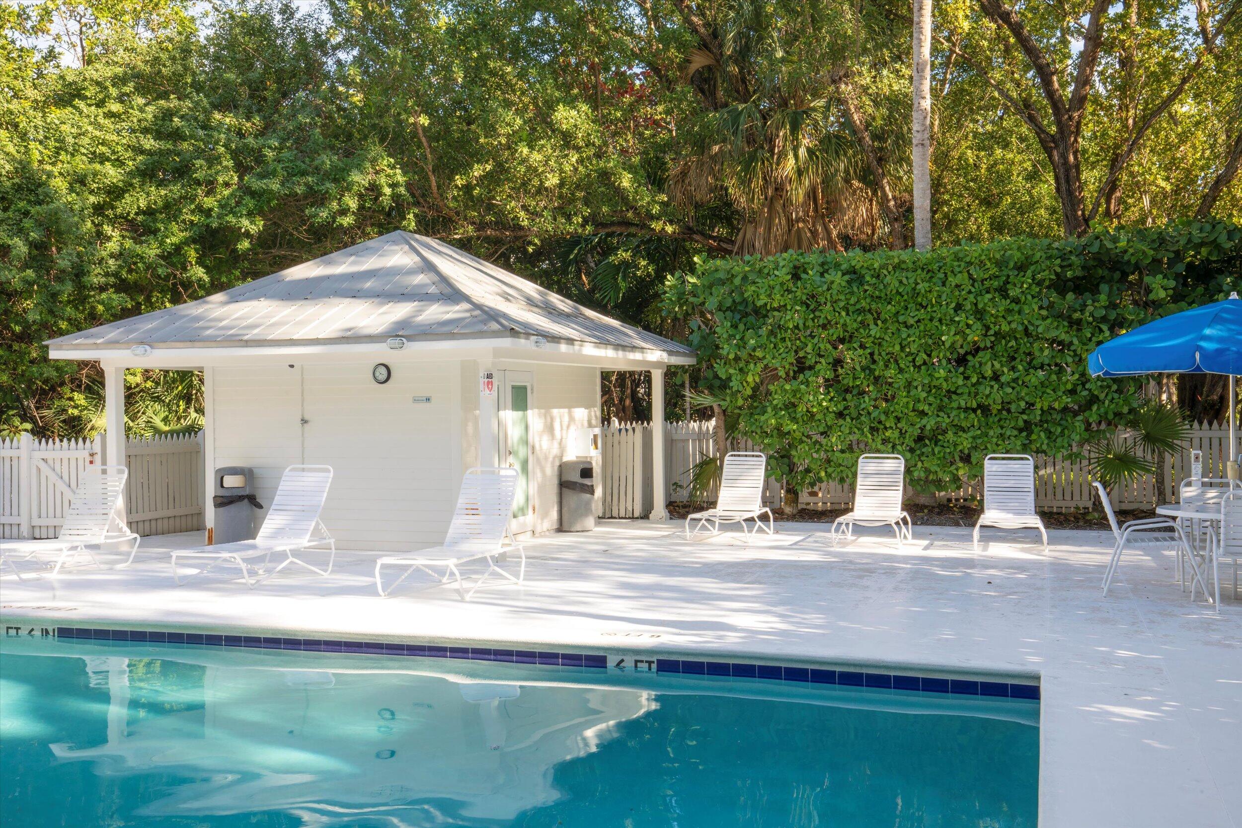 44 Spoonbill Way, Unit 1 Key West, FL 33040 - Photo 77 of 83 a backyard of a house with table and chairs