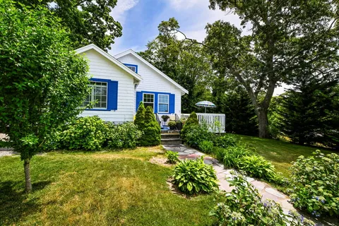 a front view of a house with yard and green space