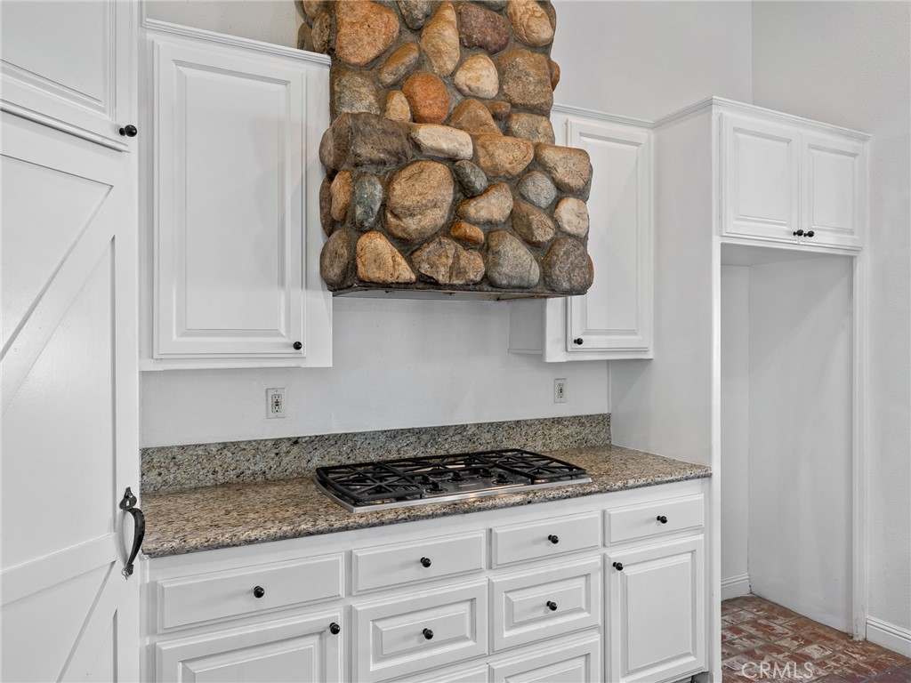 8135 Winmar Road Hesperia, CA 92344 - Photo 16 of 52 a kitchen with white cabinets and a stove with wooden floor