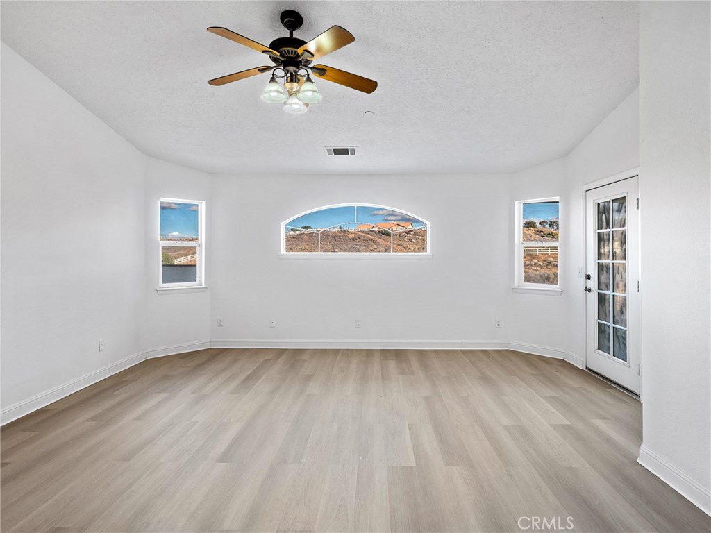 8135 Winmar Road Hesperia, CA 92344 - Photo 20 of 52 a view of an empty room window and wooden floor