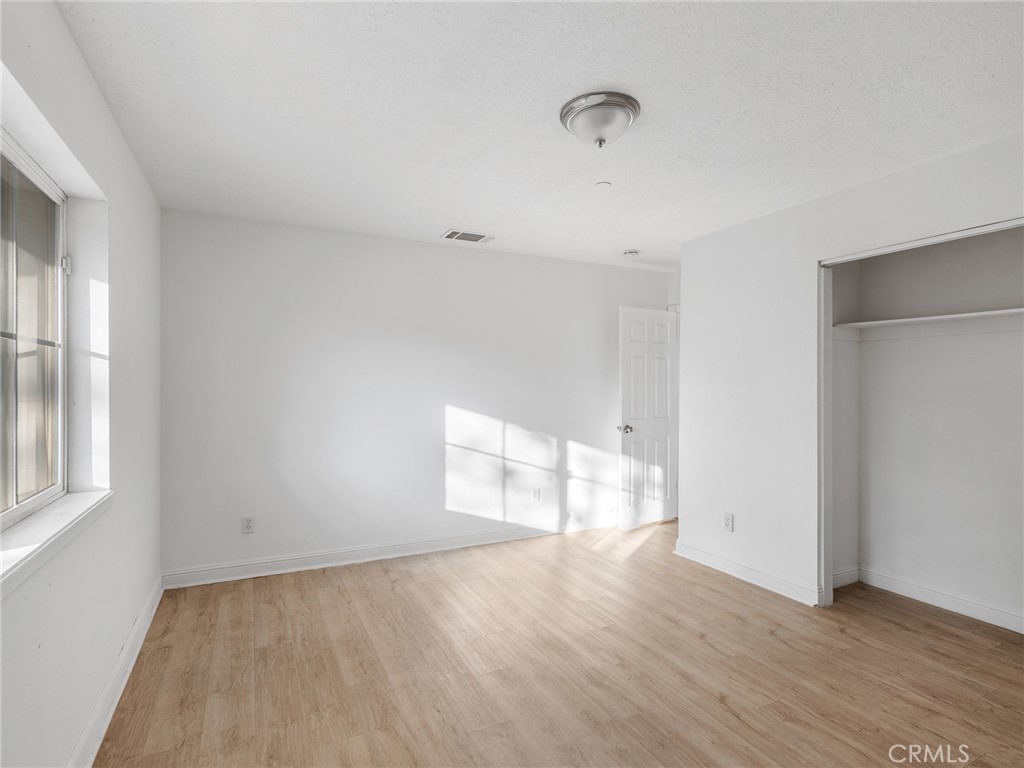 8135 Winmar Road Hesperia, CA 92344 - Photo 33 of 52 an empty room with wooden floor and windows