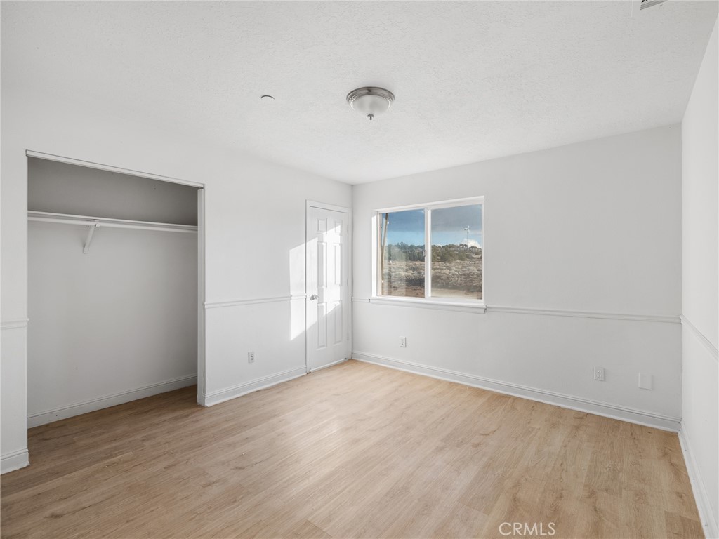 8135 Winmar Road Hesperia, CA 92344 - Photo 34 of 52 an empty room with wooden floor and windows