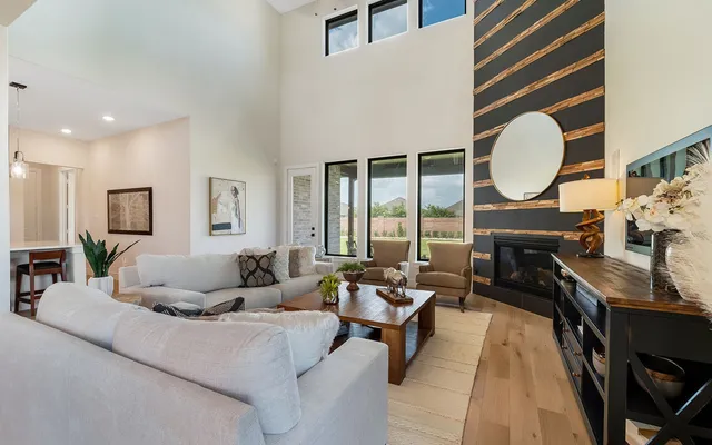 a living room with furniture a large window and wooden floor