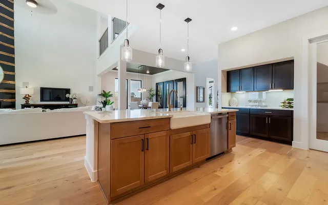 a kitchen with stainless steel appliances kitchen island granite countertop a sink a stove and a refrigerator