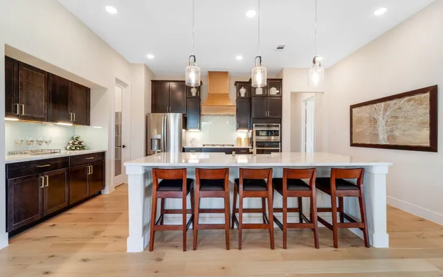 a dining room with stainless steel appliances kitchen island granite countertop a dining table and chairs
