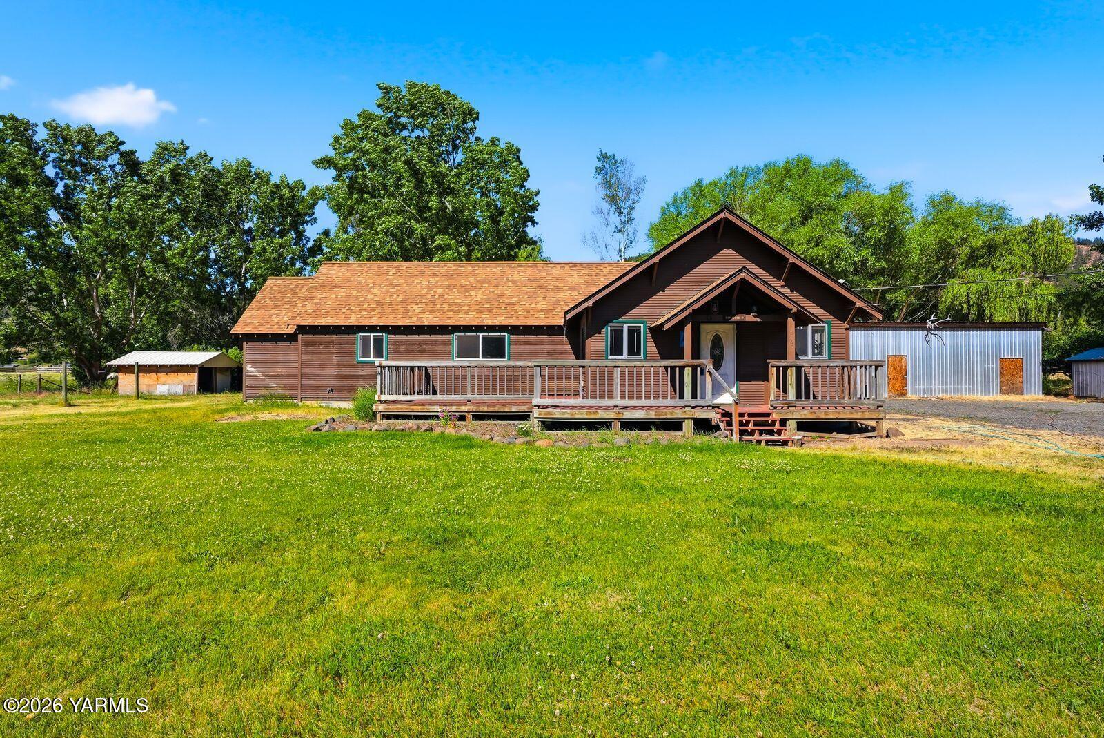 a front view of a house with yard and green space