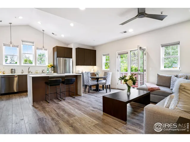 a living room with furniture kitchen view and a large window
