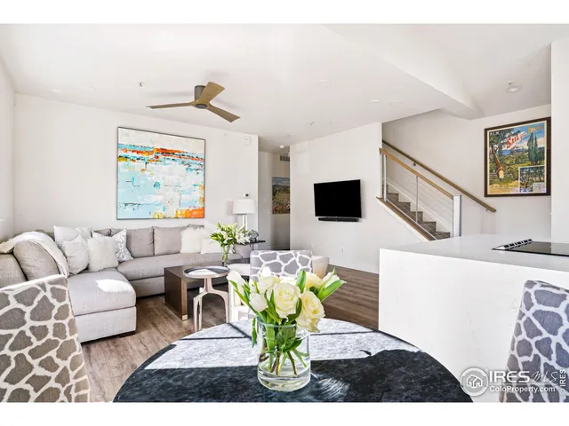 a living room with furniture flowerpot and a flat screen tv