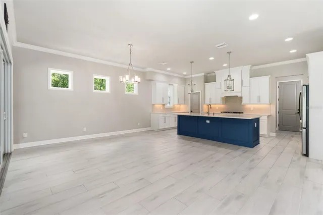 a kitchen with kitchen island granite countertop wooden cabinets and refrigerator