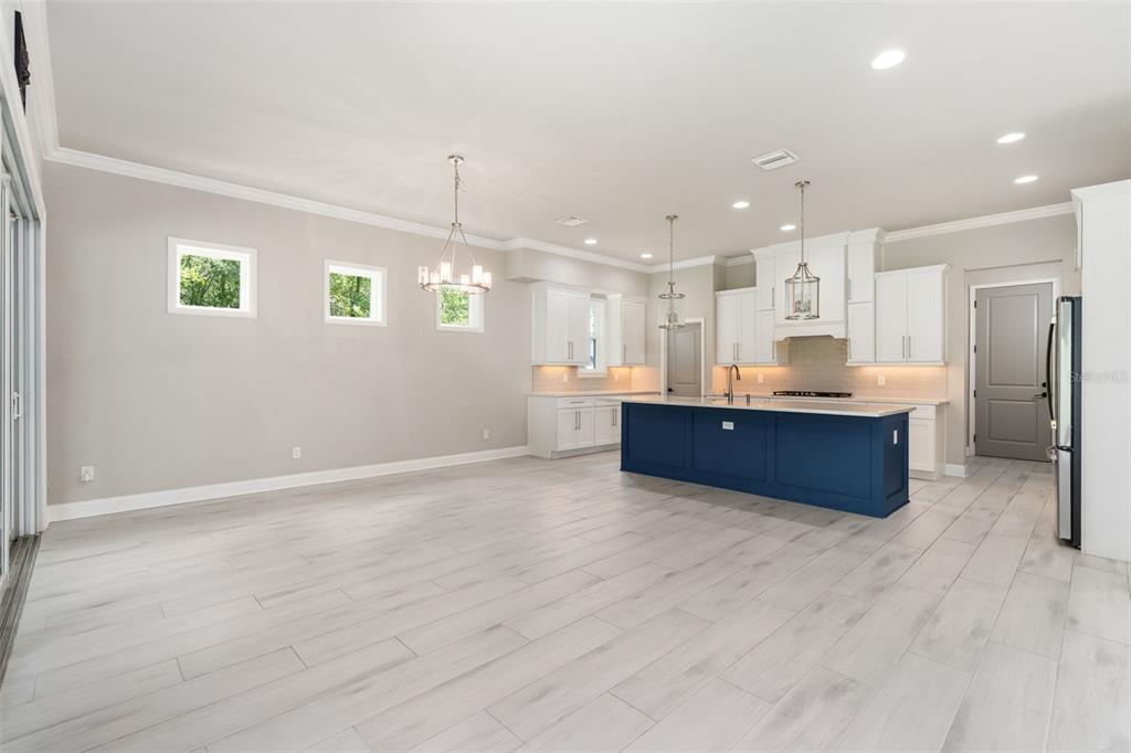 3474 Southwest 109 Drive Gainesville, FL 32608 - Photo 12 of 60 a large kitchen with stainless steel appliances kitchen island granite countertop a large cabinets a sink and a counter top space