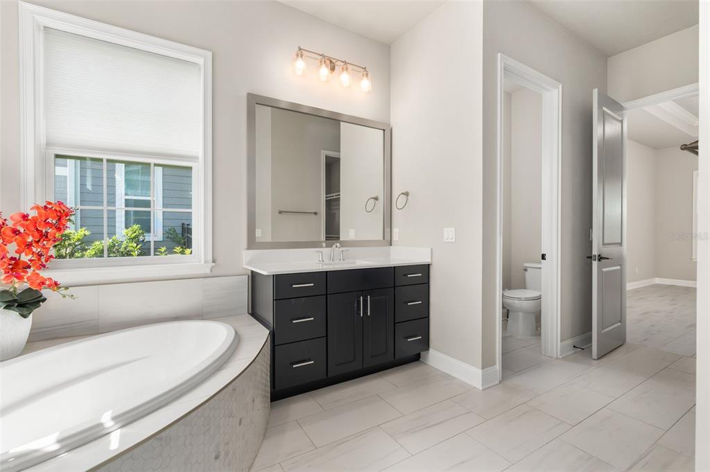 3474 Southwest 109 Drive Gainesville, FL 32608 - Photo 30 of 60 a bathroom with a tub sink and mirror