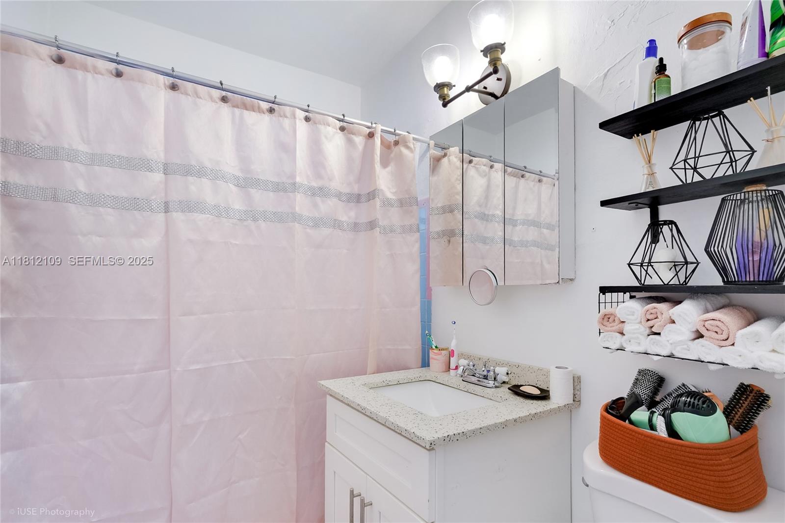 901 Southwest 34th Avenue Miami, FL 33135 - Photo 8 of 18 a bathroom with a sink a mirror and shower curtain