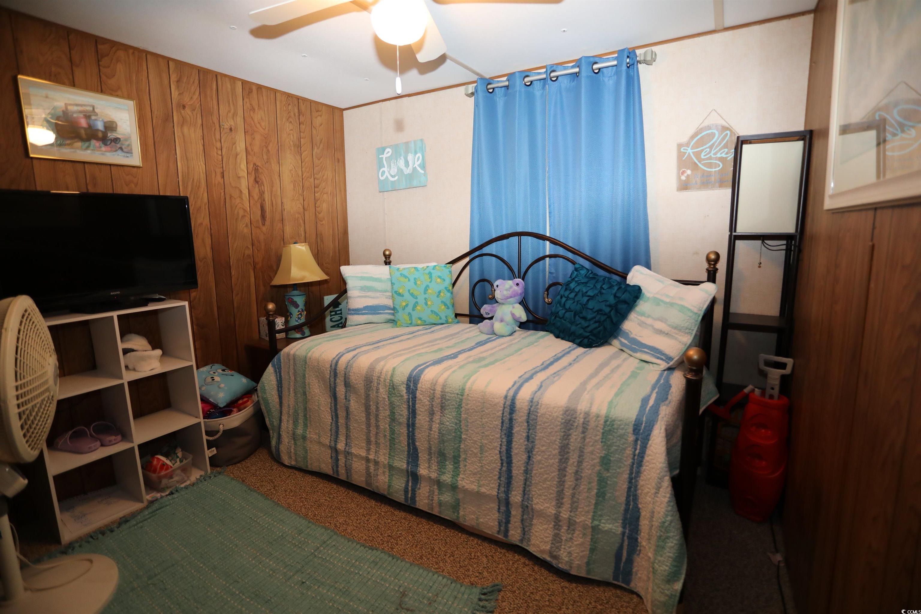 724 1st Street Murrells Inlet, SC 29576 - Photo 11 of 18 Bedroom with ceiling fan, carpet floors, and wooden walls
