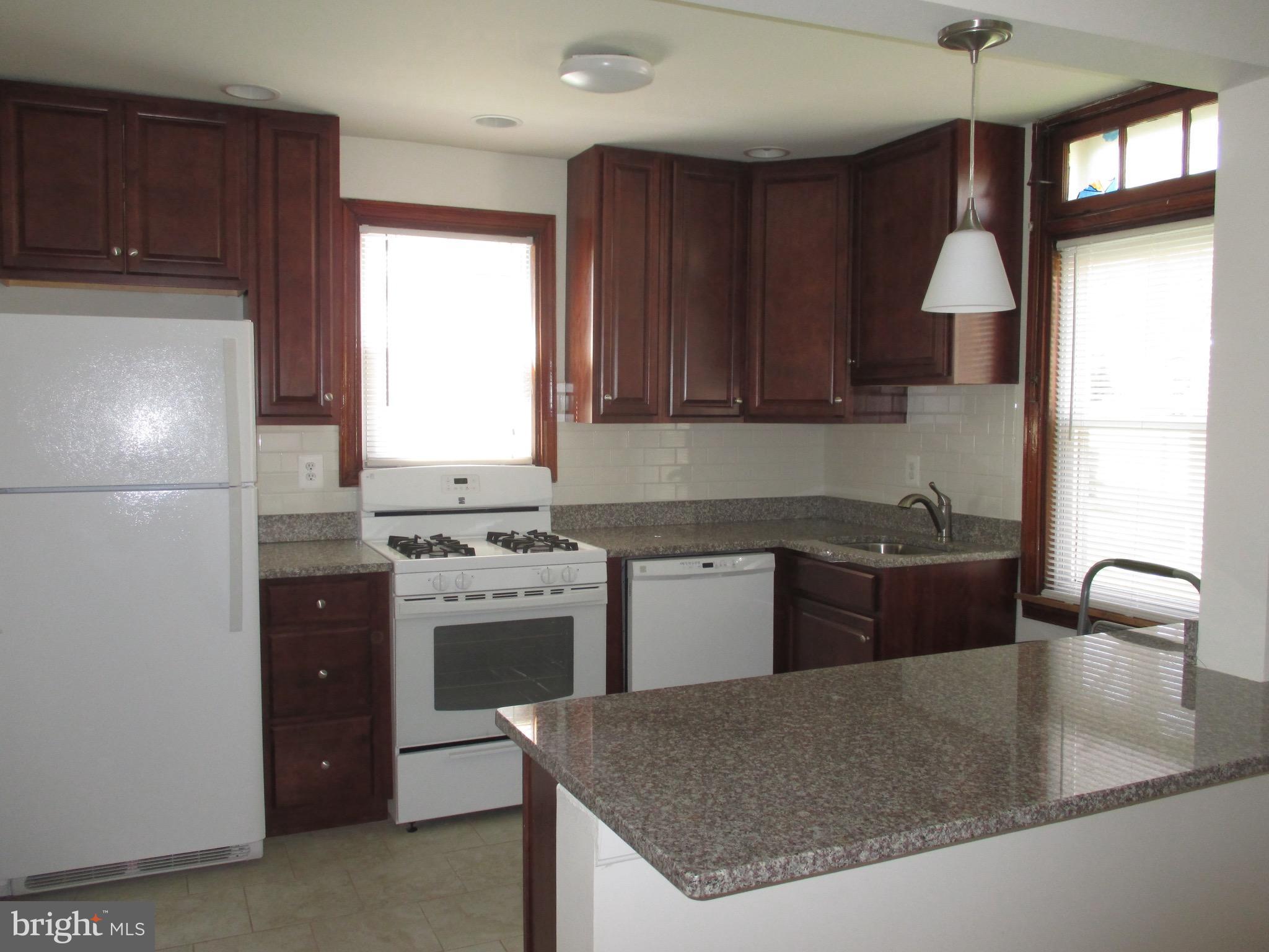 716 Dorchester Road Baltimore, MD 21229 - Photo 3 of 20 a kitchen with a stove a refrigerator and a sink