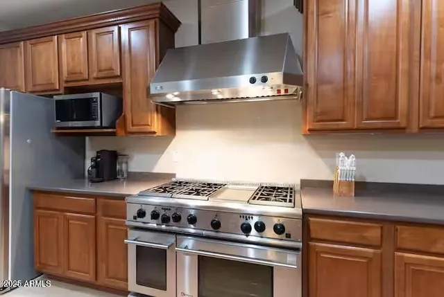 a kitchen with wooden cabinets and a stove top oven