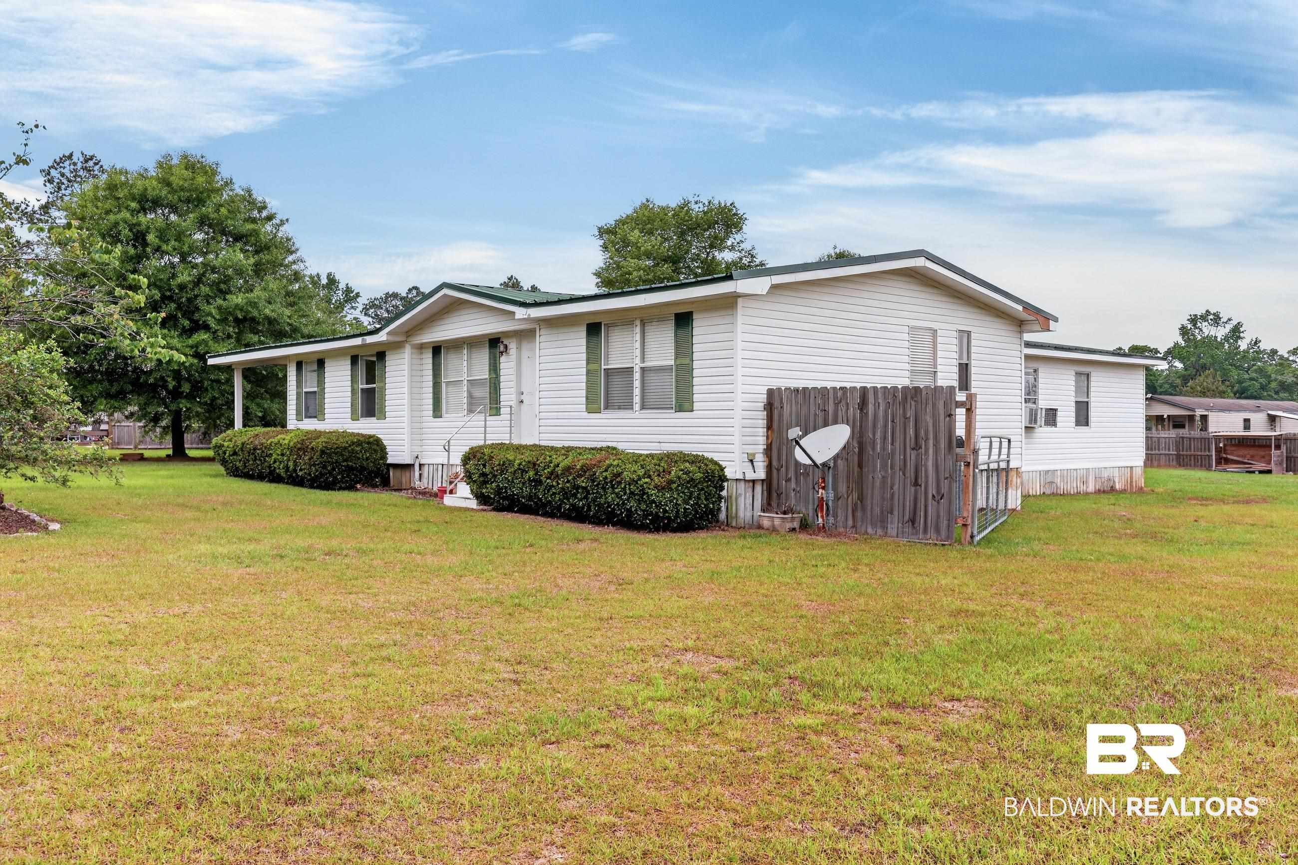 24903 Patterson Road Robertsdale, AL 36567 - Photo 8 of 57 White siding home featuring a green shingle roof and front porch