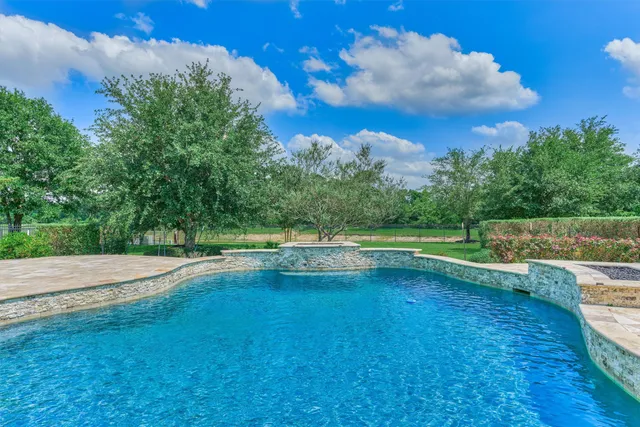 a view of yard with swimming pool and green space
