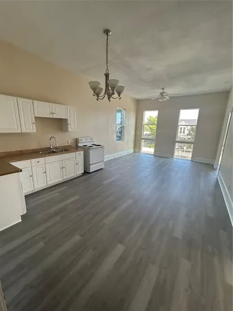 a view of a kitchen with a sink dishwasher a refrigerator and wooden floor