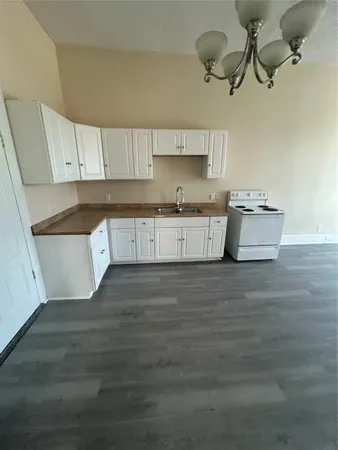 a kitchen with stainless steel appliances granite countertop a white cabinets a stove top oven a sink and dishwasher