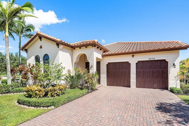 a view of a house with a yard and potted plants