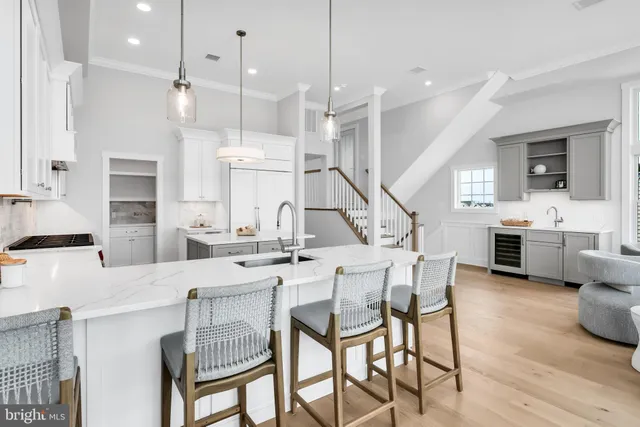 a kitchen with stainless steel appliances kitchen island granite countertop a table chairs sink and cabinets