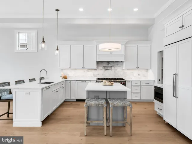 a kitchen with kitchen island granite countertop a sink stainless steel appliances and white cabinets