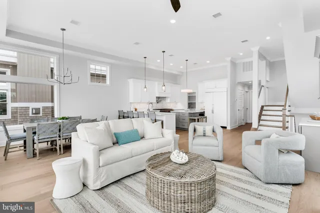 a living room with furniture kitchen view and a chandelier
