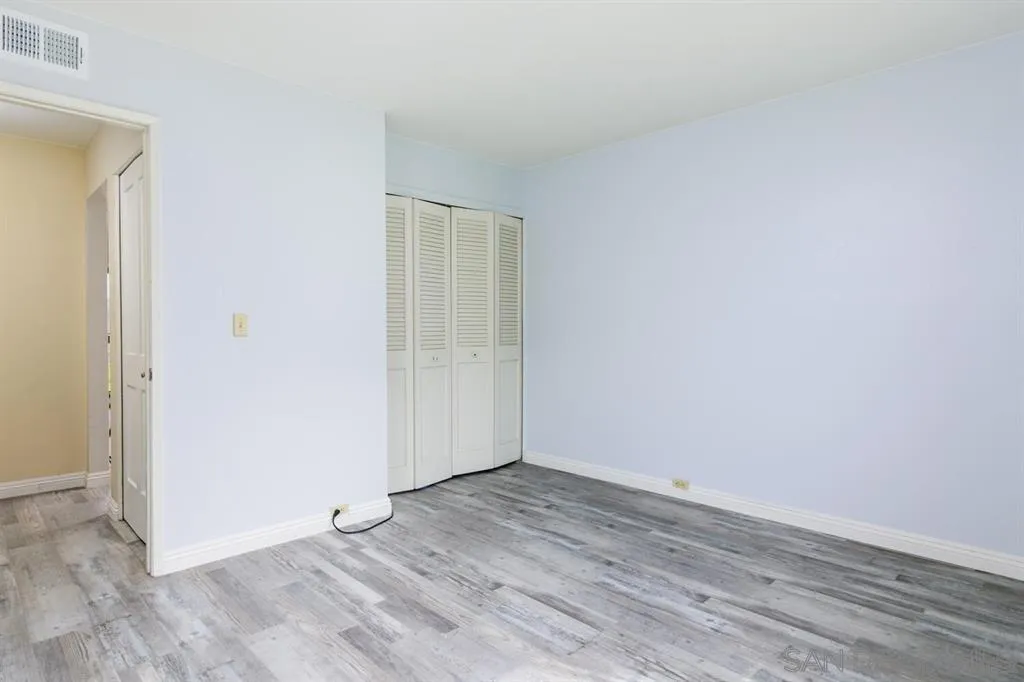 5125 Fontaine Street, Unit 205 San Diego, CA 92120 - Photo 11 of 18 an empty room with wooden floor and windows