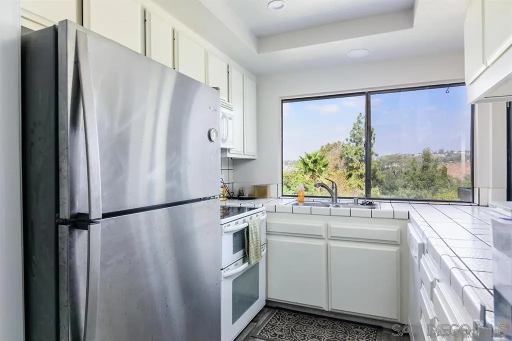 5125 Fontaine Street, Unit 205 San Diego, CA 92120 - Photo 5 of 18 a white refrigerator freezer sitting inside of a kitchen