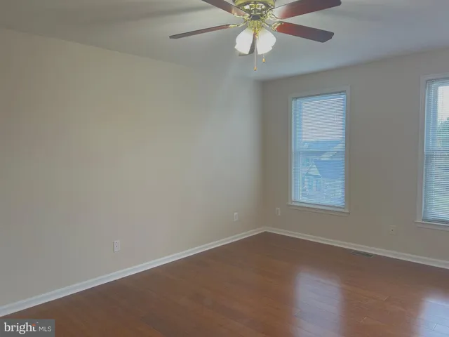 a view of a livingroom with wooden floor and a ceiling fan