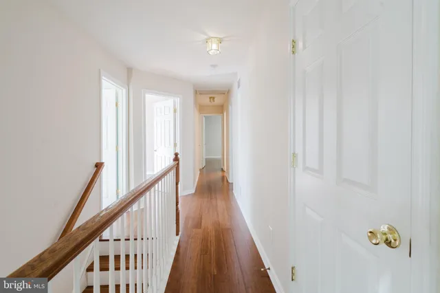 an empty room with wooden floor chandelier fan and windows