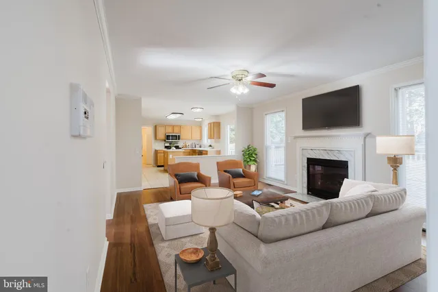 a large kitchen with stainless steel appliances granite countertop a stove top oven a sink a dishwasher a dining table and chairs with wooden floor