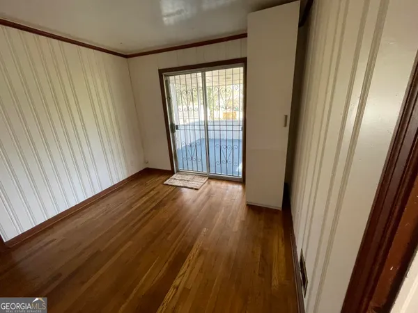a view of a room with wooden floor and door