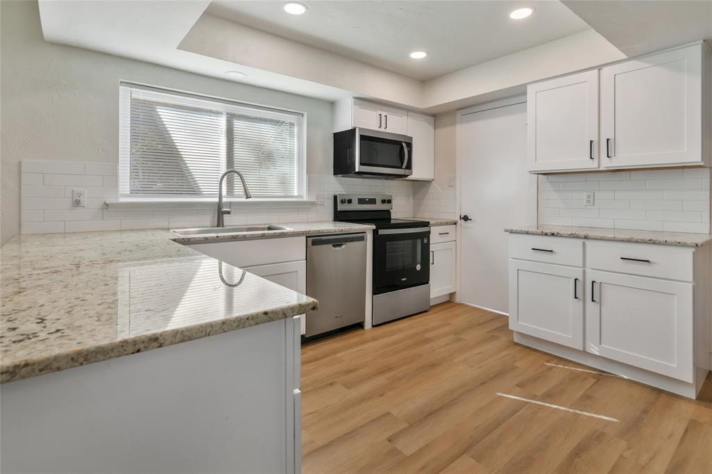 3708 Spring Meadow Lane Flower Mound, TX 75028 - Photo 15 of 39 a kitchen with stainless steel appliances granite countertop a sink dishwasher a stove and a microwave oven with cabinets