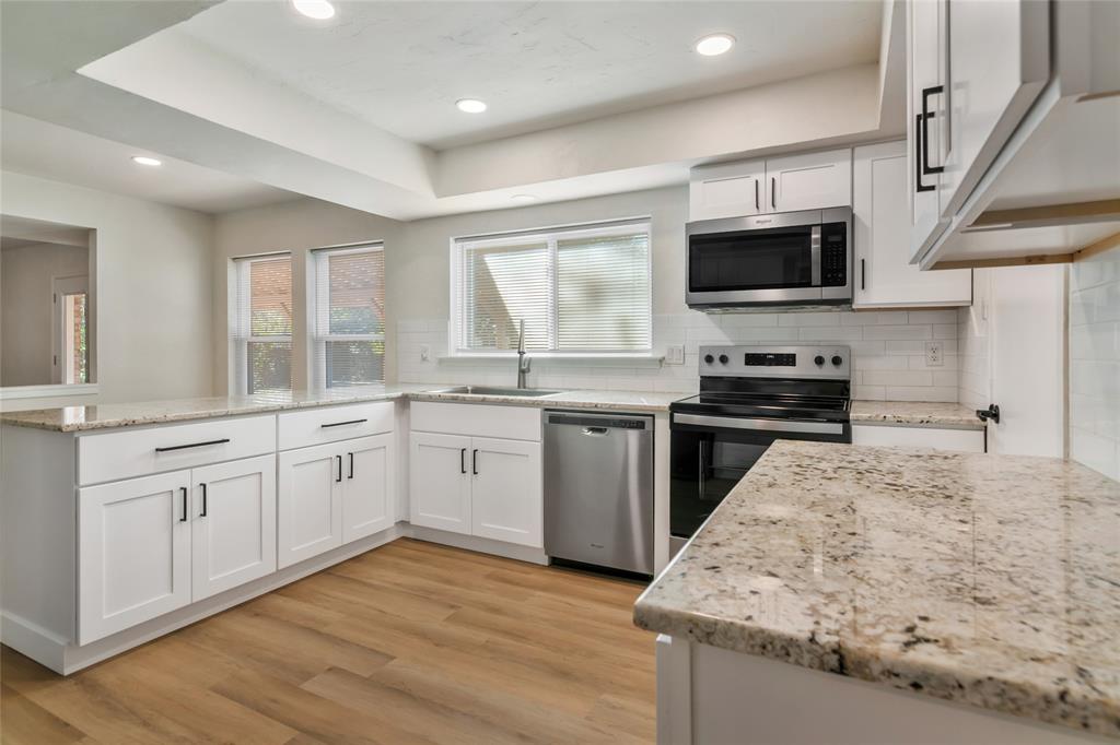 3708 Spring Meadow Lane Flower Mound, TX 75028 - Photo 16 of 39 a kitchen with stainless steel appliances granite countertop a sink dishwasher stove and microwave with wooden floor