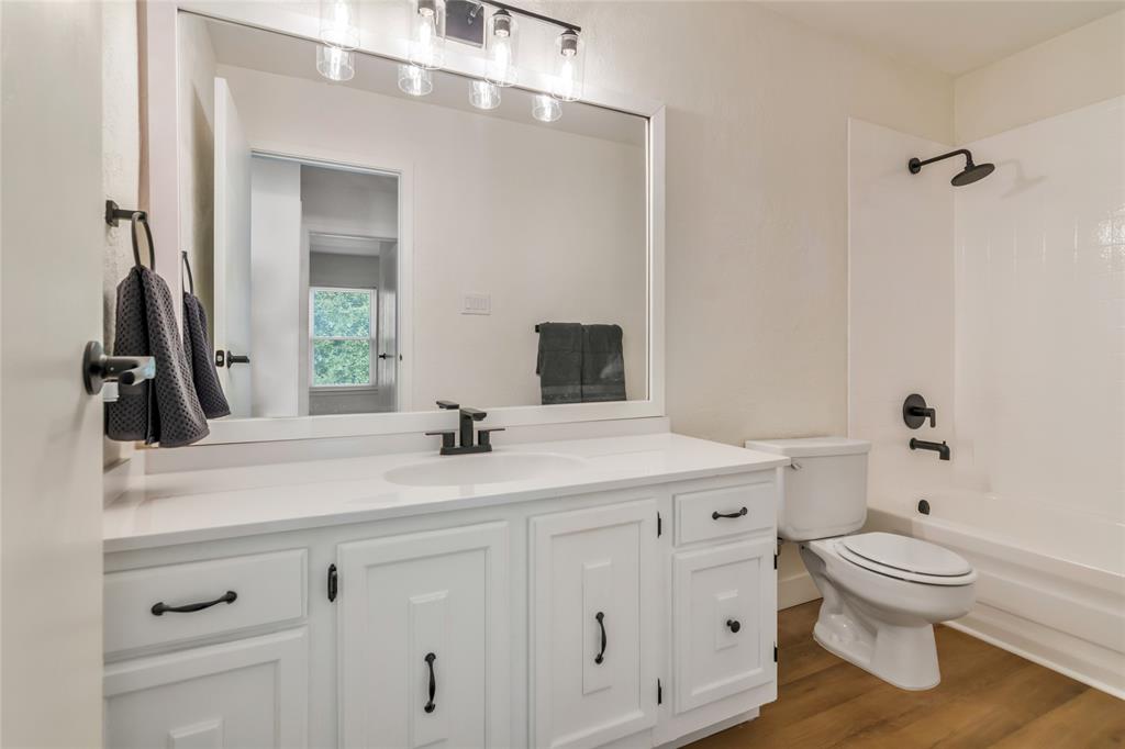 3708 Spring Meadow Lane Flower Mound, TX 75028 - Photo 31 of 39 a bathroom with a sink a toilet and a mirror