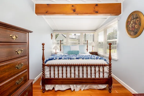 a bedroom with a bed and wooden floor