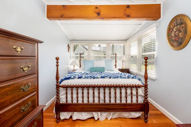 a bedroom with a bed and wooden floor