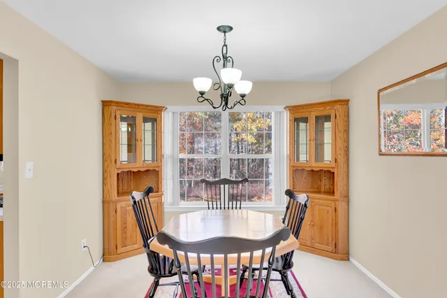 a dining room with furniture a chandelier and window