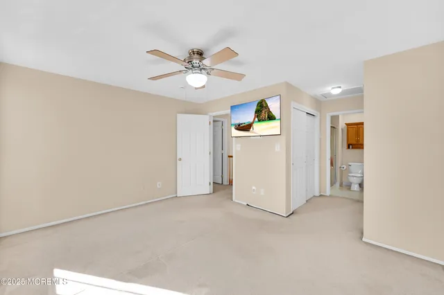 a view of a kitchen with a fridge and ceiling fan